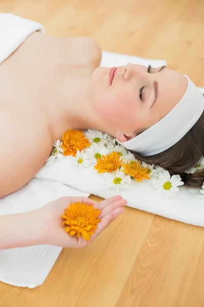 Beautiful woman with eyes closed and flowers in beauty salon — Stock Photo, Image