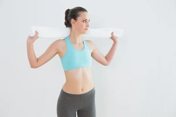 Ajuste mujer con toalla alrededor del cuello contra la pared — Foto de Stock