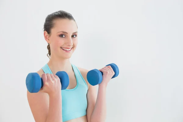Mulher sorridente com halteres no estúdio de fitness — Fotografia de Stock