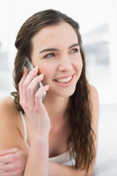 Close up van ontspannen vrouw met behulp van mobiele telefoon in bed — Stockfoto