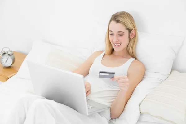 Preciosa mujer de compras en casa con su cuaderno acostado en su cama — Foto de Stock