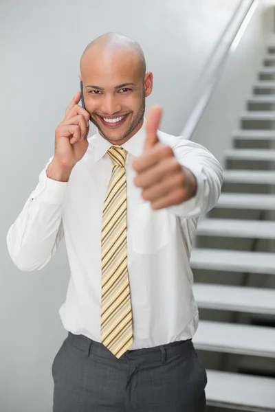 Geschäftsmann benutzt Handy und gestikuliert mit erhobenem Daumen — Stockfoto