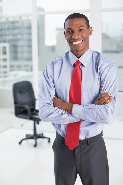 Elegante e sorridente empresário afro em pé no cargo — Fotografia de Stock