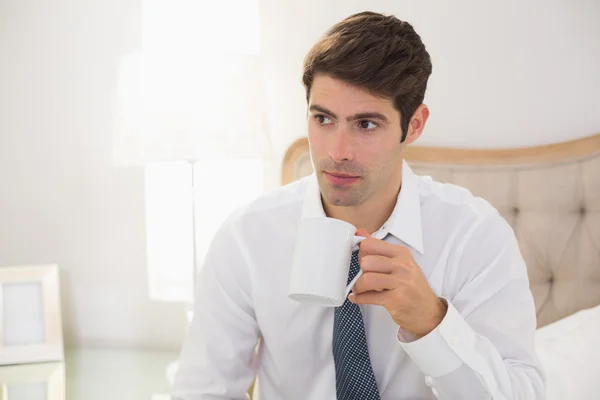 ベッドの中でコーヒーを飲んでも身なりの男の笑みを浮かべてください。 — ストック写真