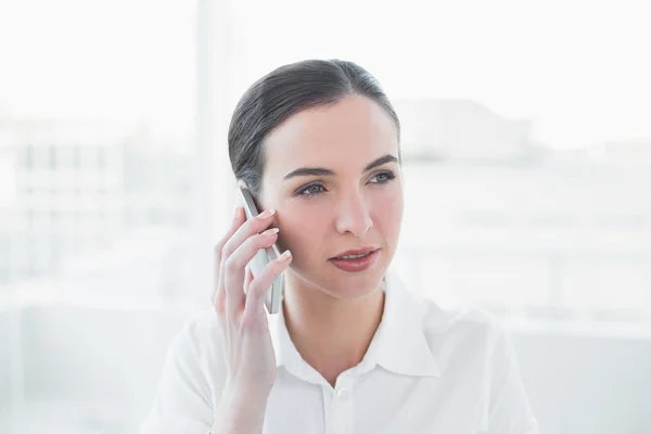 Seriöse Geschäftsfrau mit Handy im Büro — Stockfoto