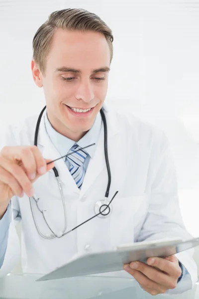 Uśmiechnięty mężczyzna lekarz patrząc na cyfrowy tablicowy — Zdjęcie stockowe
