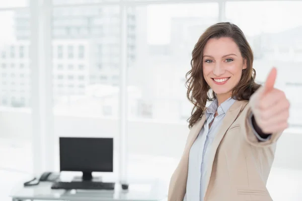 Elegant smiling businesswoman gesturing thumbs up in office — Stock Photo, Image