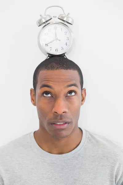 Close up of a man with an alarm clock on top of his head — Stock Photo, Image