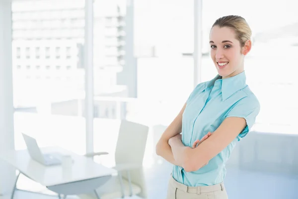 Schöne junge Geschäftsfrau posiert mit verschränkten Armen in ihrem Büro — Stockfoto