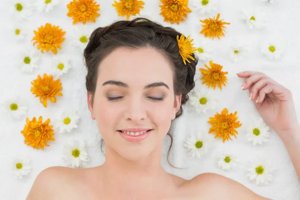 Belle femme avec les yeux fermés et des fleurs dans le salon de beauté — Photo