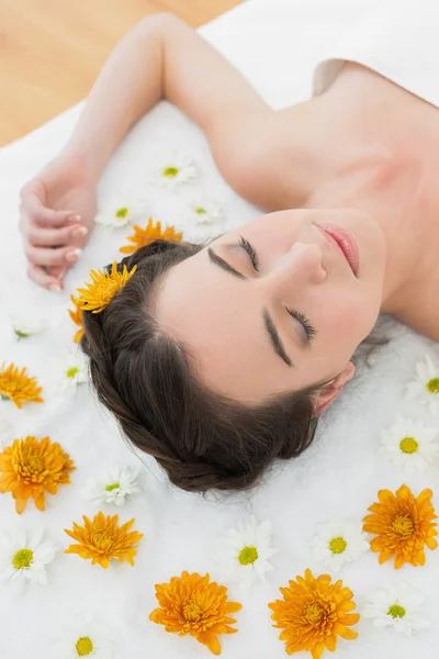 Hermosa mujer con los ojos cerrados y flores en salón de belleza —  Fotos de Stock