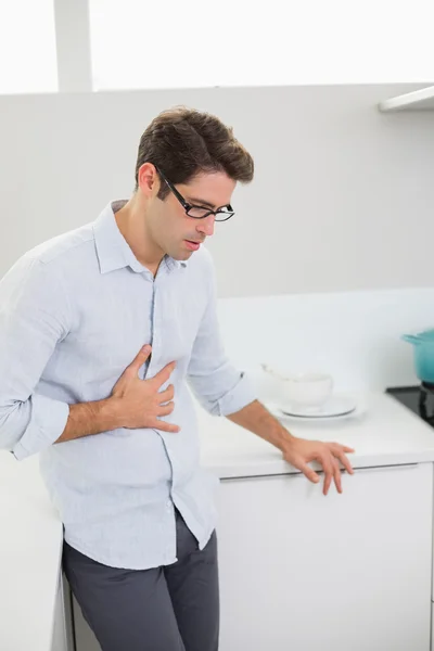 Retrato de homem casual com dor de estômago na cozinha — Fotografia de Stock