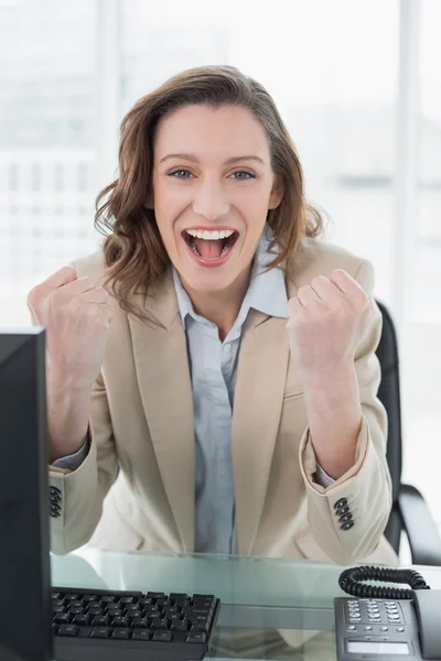 Businesswoman cheering with clenched fists in office — Stock Photo, Image