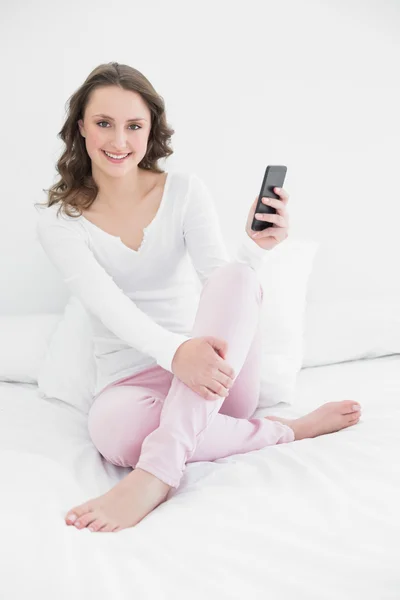Usměvavá mladá žena s mobilním telefonem — Stock fotografie
