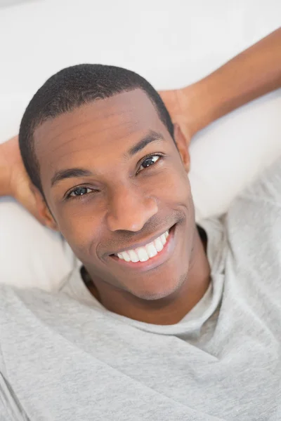 Sonriente joven Afro hombre descansando en la cama — Foto de Stock