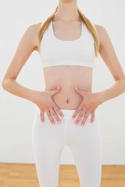 Slender sporty woman touching her belly — Stock Photo, Image
