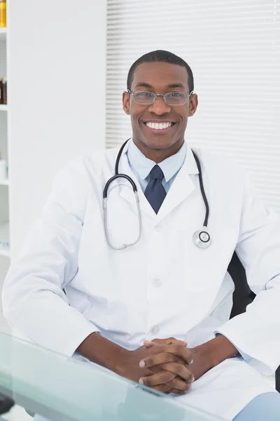 Smiling doctor with arms crossed in a medical office — Stock Photo, Image