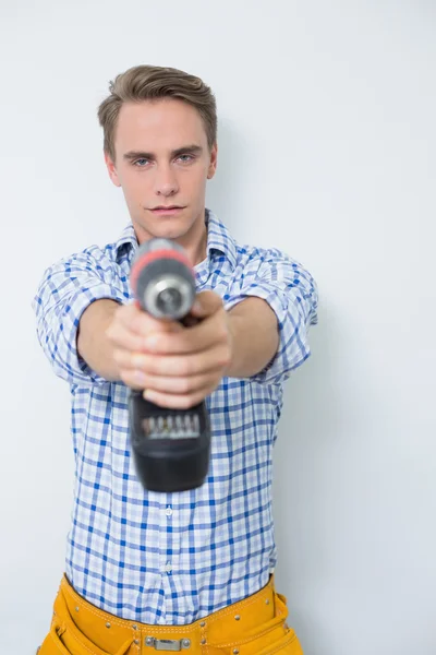 Smiling handsome young handyman holding drill — Stock Photo, Image