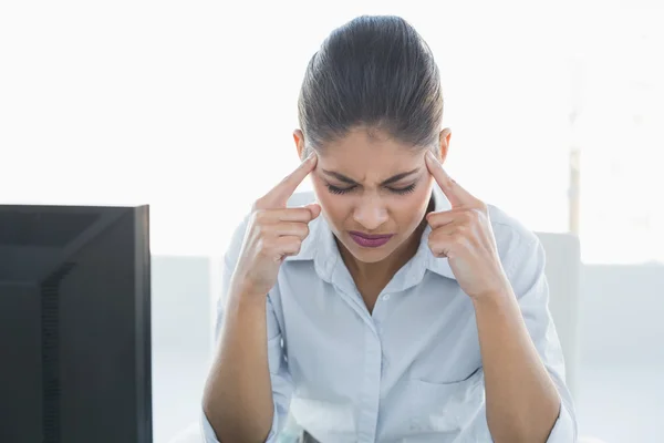Empresária sofrendo de dor de cabeça na frente do computador — Fotografia de Stock