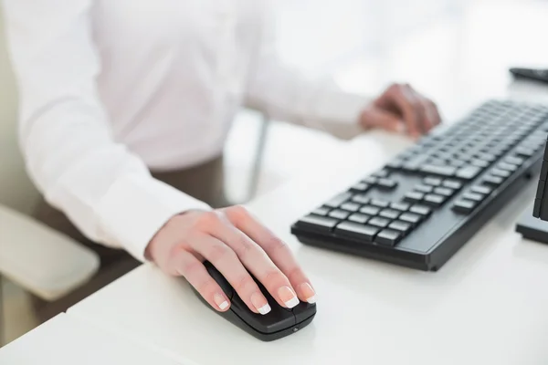 Sección media de la mujer de negocios con el ratón en la oficina — Foto de Stock