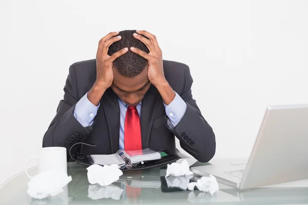 Frustrado hombre de negocios afro con la cabeza en las manos en el escritorio — Foto de Stock