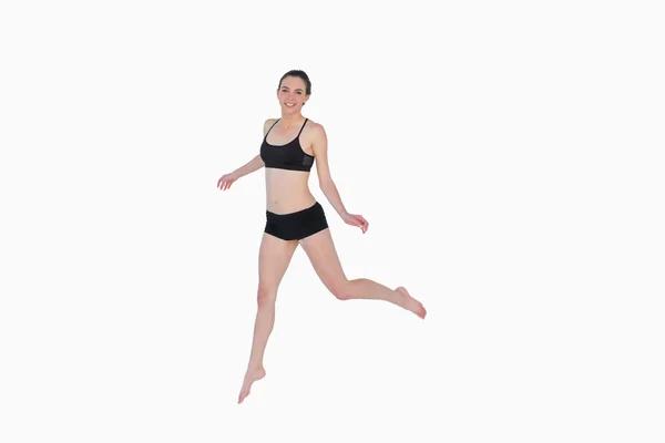 Lunghezza completa di una giovane donna sportiva che salta — Foto Stock