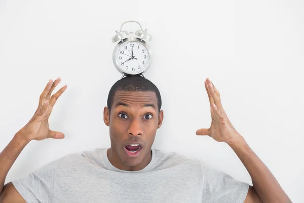 Shocked man with an alarm clock on top of his head — Stock Photo, Image