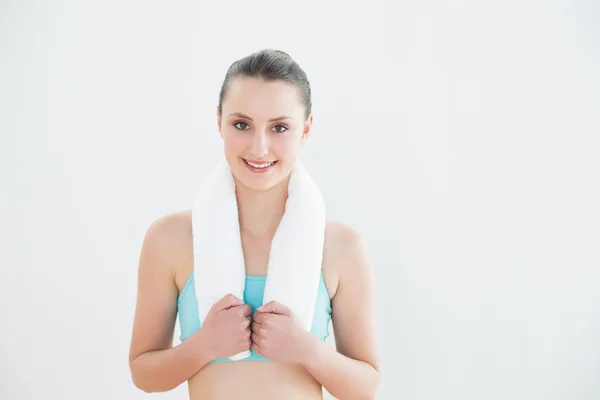 Fit žena s ručníkem kolem krku proti zdi — Stock fotografie