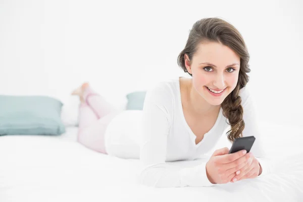Mujer mirando el teléfono móvil en la cama —  Fotos de Stock
