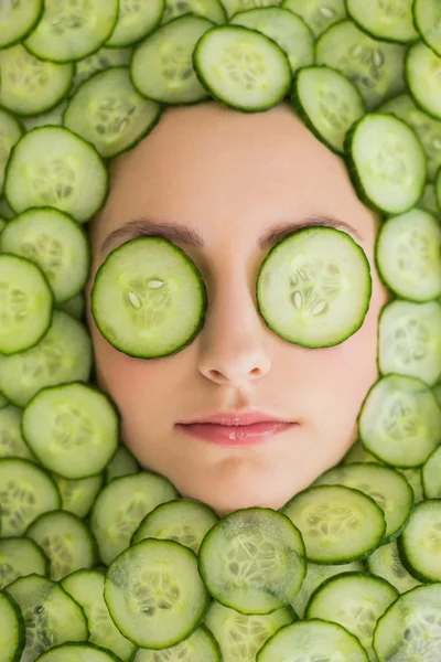 Hermosa mujer con máscara facial de rodajas de pepino en la cara — Foto de Stock