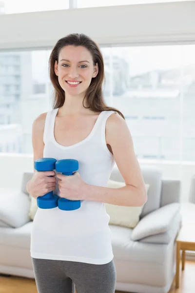 Fit woman exercising with dumbbells in fitness studio — Stock Photo, Image
