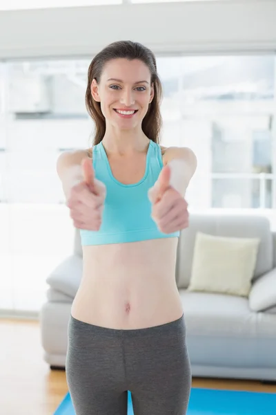 Durchtrainierte Frau gestikuliert Daumen hoch im Fitnessstudio — Stockfoto