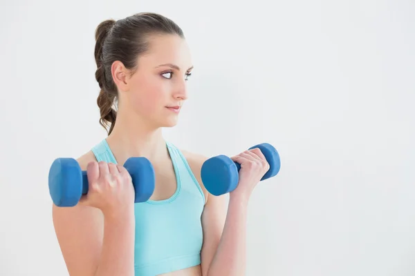 Woman with dumbbells at fitness studio — Stock Photo, Image