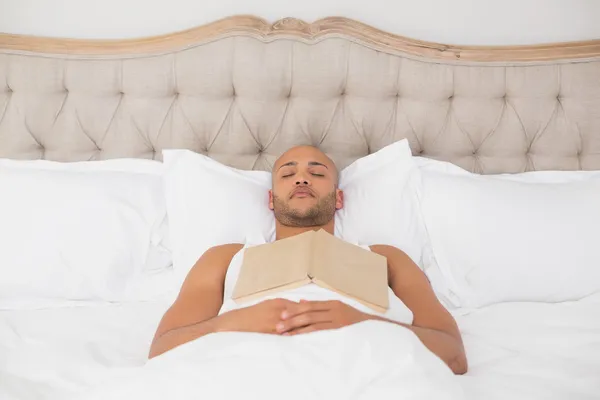 Yatakta yatarken kitap ile rahat adam — Stok fotoğraf