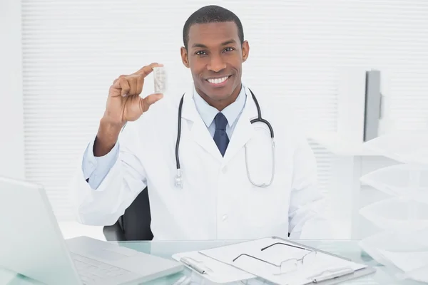 Médico sério que escreve uma receita no consultório médico — Fotografia de Stock