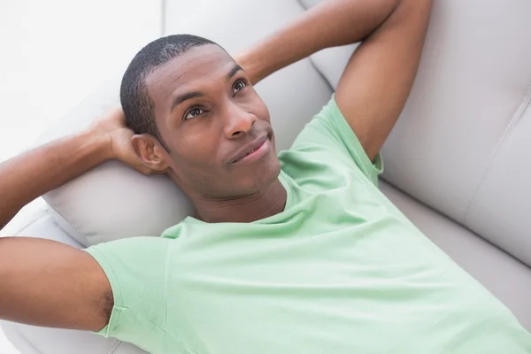 Thoughtful relaxed young Afro man lying on sofa — Stock Photo, Image