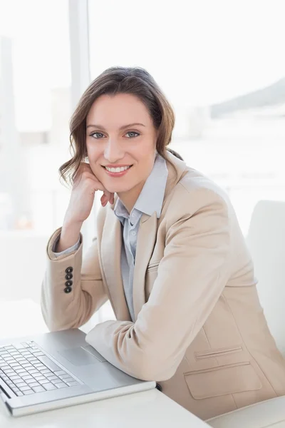 Lächelnde junge Geschäftsfrau mit Laptop im Büro — Stockfoto