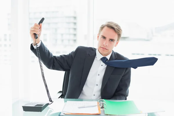 Businessman holding out phone at office — Stock Photo, Image