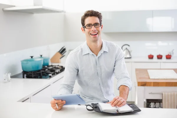 Hombre alegre casual con tableta digital y diario en la cocina — Foto de Stock