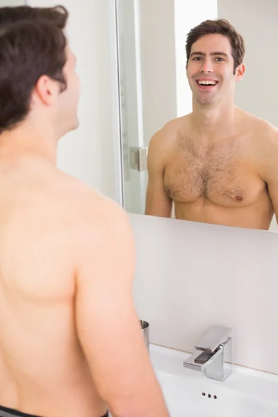 Reflexão do homem sem camisa sorrindo no banheiro — Fotografia de Stock