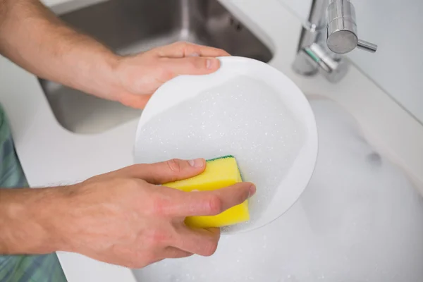 Mãos a lavar a louça na pia da cozinha — Fotografia de Stock