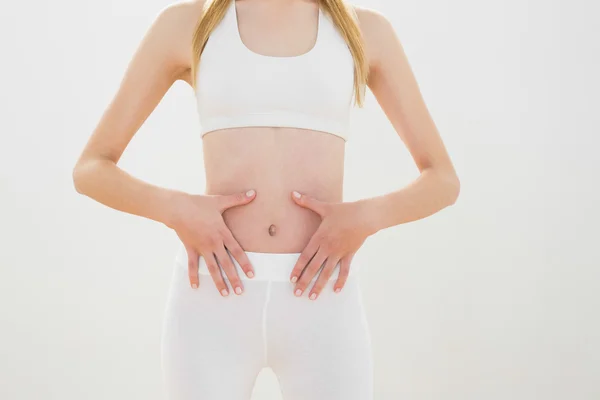 Schlanke, sportliche Frau, die ihren Bauch berührt — Stockfoto