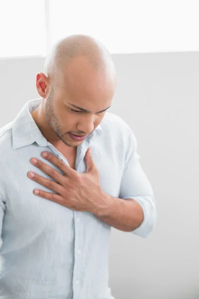 Casual young man with chest pain — Stock Photo, Image