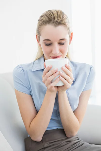 Avslappnad lugn affärskvinna innehar en kopp luktar det — Stockfoto