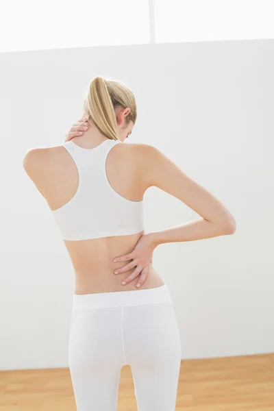 Sporty blonde woman touching her injured nape — Stock Photo, Image