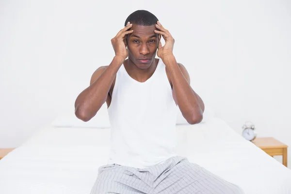 Afro man suffering from headache in bed — Stock Photo, Image