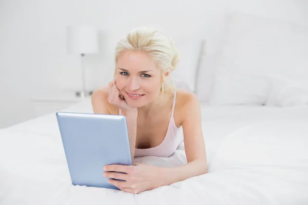 Content casual young blond using tablet PC in bed — Stock Photo, Image