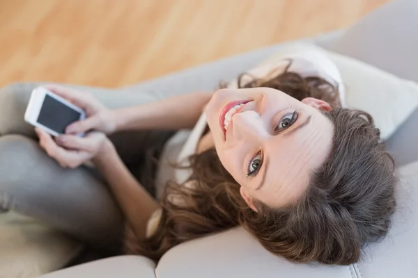 Overhead porträtt av en kvinna med mobiltelefon på soffa — Stockfoto