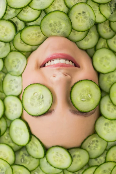 Hermosa mujer con máscara facial de rodajas de pepino en la cara — Foto de Stock