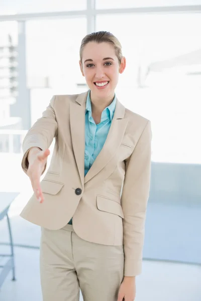 Chic businesswoman reaching her hand smiling friendly at camera — Stock Photo, Image